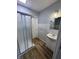 Cozy bathroom featuring a glass-enclosed shower, a classic vanity, and clean white tiles with a wavy accent at 1445 S Belmont Ave, Indianapolis, IN 46221