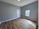 Bright bedroom with neutral walls, wood-look floors, and a window with natural light at 1445 S Belmont Ave, Indianapolis, IN 46221