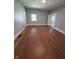 Bedroom featuring neutral walls, hardwood floors, a window, and two doorways at 1445 S Belmont Ave, Indianapolis, IN 46221