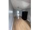 Spacious living room with light gray walls, wood-look flooring and a black refrigerator at 1445 S Belmont Ave, Indianapolis, IN 46221