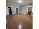 Large living room with wood-look flooring, gray walls, and multiple doorways for easy flow at 1445 S Belmont Ave, Indianapolis, IN 46221