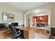 A well-lit home office with a large desk, multiple monitors, and a peek into the adjacent dining room at 1484 N County Road 900 E, Avon, IN 46123