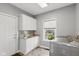 Efficient laundry room featuring white cabinets, granite countertop, and modern washer and dryer at 1484 N County Road 900 E, Avon, IN 46123