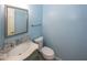 Powder room with a pedestal sink, decorative mirror, and soft, light-blue walls at 1509 Copperwood Pl, Carmel, IN 46033