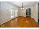 Traditional dining room with wood floors, floral wallpaper, and french doors leading to the backyard at 1509 Copperwood Pl, Carmel, IN 46033