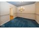 Formal dining room with elegant chandelier, blue carpet, and decorative wall trim at 1509 Copperwood Pl, Carmel, IN 46033