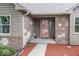 Close up of home's entrance featuring brick and stone accents, plus a welcoming red-trimmed glass front door at 1509 Copperwood Pl, Carmel, IN 46033