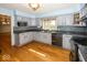 Well-lit kitchen boasts stylish blue cabinets, modern appliances, granite counters and hardwood floors at 1509 Copperwood Pl, Carmel, IN 46033