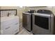 Updated laundry room with modern washer and dryer, utility sink, and decorative backsplash at 1509 Copperwood Pl, Carmel, IN 46033