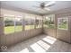 Bright sunroom with tile floors, large windows overlooking the yard, and a ceiling fan at 1509 Copperwood Pl, Carmel, IN 46033