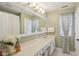 Bright bathroom features a large mirror, a long white countertop, and a window for natural light and ventilation at 15129 Smithfield Dr, Westfield, IN 46074