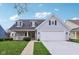 Charming home featuring a well-manicured lawn, a welcoming front porch, and a two-car garage at 15129 Smithfield Dr, Westfield, IN 46074