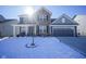 Two-story home with brick and siding, a two-car garage, and a small tree in the snowy front yard at 15365 Todd S Ln, Fishers, IN 46037