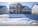 Two-story home with brick and siding, a two-car garage, and a small tree in the snowy front yard at 15365 Todd S Ln, Fishers, IN 46037