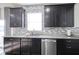 Well-appointed kitchen showcases dark cabinetry, mosaic tile backsplash, stainless steel appliances, and granite countertops at 15365 Todd S Ln, Fishers, IN 46037