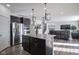 Modern kitchen featuring dark cabinets, granite countertops, stainless steel appliances, and stylish pendant lighting at 15365 Todd S Ln, Fishers, IN 46037
