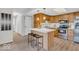 Functional kitchen with wooden cabinetry, stainless steel appliances, and a central island with seating at 1632 Queensbridge Sq # 7, Indianapolis, IN 46219