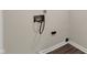 This is a close-up of the laundry hookups with wood look flooring and light-colored walls at 1632 Queensbridge Sq # 7, Indianapolis, IN 46219