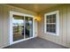 This is a view of the carpeted patio with a sliding glass door and a window at 1632 Queensbridge Sq # 7, Indianapolis, IN 46219