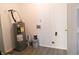 This utilitarian room includes a water heater, paint supplies, and a door to somewhere else at 1643 Kayla Dr, Indianapolis, IN 46234