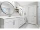 Modern bathroom features a double vanity with granite countertops and sleek, round mirrors at 16688 Bowesmont Dr, Fortville, IN 46040