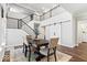Modern dining area boasts a rustic table, staircase with metal railings, and a sliding barn door feature at 16688 Bowesmont Dr, Fortville, IN 46040