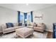Comfortable living room boasts plush seating, neutral decor, and blue accent pillows with natural lighting at 16688 Bowesmont Dr, Fortville, IN 46040