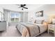 Bright main bedroom with a patterned bedspread, a ceiling fan, and an exterior view at 16688 Bowesmont Dr, Fortville, IN 46040