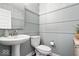Stylish powder room featuring gray wainscoting, modern fixtures, vessel sink, and patterned wallpaper at 16688 Bowesmont Dr, Fortville, IN 46040