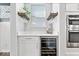 Elegant wine bar with built-in cooler, quartz countertop, wine glass racks, and stainless steel appliances at 16688 Bowesmont Dr, Fortville, IN 46040