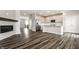 Open-concept living room and kitchen area boasts dark wood-look flooring and stainless steel appliances at 17372 Graley Pl, Westfield, IN 46074