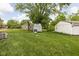 Backyard with a barn, detached garage, and large green lawn at 207 Stephen Ct, Indianapolis, IN 46280