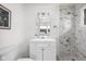 Bright bathroom featuring modern vanity, decorative mirror, and marble-tiled shower at 207 Stephen Ct, Indianapolis, IN 46280