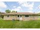 Back exterior view of ranch home with stone siding, manicured lawn, and roof chimney at 207 Stephen Ct, Indianapolis, IN 46280