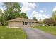 Well-maintained ranch home featuring a long driveway, stone facade, and mature landscaping at 207 Stephen Ct, Indianapolis, IN 46280