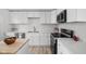 Modern kitchen featuring white cabinets, updated appliances, and a functional cooking space at 207 Stephen Ct, Indianapolis, IN 46280
