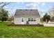 Backyard of home featuring neutral siding, a chair on the deck, and a well-manicured lawn at 218 Urban St, Danville, IN 46122