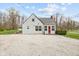 Charming home featuring neutral siding, a red front door, and a gravel driveway at 218 Urban St, Danville, IN 46122