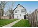 Spacious backyard with green grass, wooden fence, and an exterior door for home access at 221 Eastern Ave, Indianapolis, IN 46201