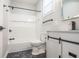 Bathroom featuring updated shower with white tile, black accents, and marble-look flooring at 221 Eastern Ave, Indianapolis, IN 46201