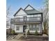 Two-story home with black and white trim, a second-story deck, and manicured landscaping at 221 Eastern Ave, Indianapolis, IN 46201