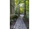 Stone walkway leading to a backyard patio seating area surrounded by trees at 23219 Marin Dr, Cicero, IN 46034