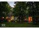 Charming home exterior featuring stone facade, mature trees, and inviting entrance with warm lighting at dusk at 23219 Marin Dr, Cicero, IN 46034