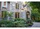 Detailed exterior shot showcasing the stone facade, arched entryway, and lush landscaping of the home at 23219 Marin Dr, Cicero, IN 46034