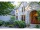 Covered entry with an arched doorway and wood door, surrounded by mature trees and lush landscaping at 23219 Marin Dr, Cicero, IN 46034