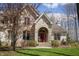 Beautiful entrance with a red door, stone archway, well-kept landscaping and mature trees at 23219 Marin Dr, Cicero, IN 46034
