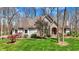 Charming exterior featuring manicured lawn, stone facade, and arched entryway with red door at 23219 Marin Dr, Cicero, IN 46034