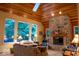 Comfortable living room featuring a stone fireplace, vaulted wood ceiling, and bright natural light from the windows at 23219 Marin Dr, Cicero, IN 46034