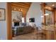 Bright living room featuring a stone fireplace, wood ceiling, and open floor plan with kitchen view at 23219 Marin Dr, Cicero, IN 46034
