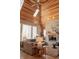 Inviting living room with vaulted wood ceiling, stone fireplace, and large windows offering scenic views at 23219 Marin Dr, Cicero, IN 46034